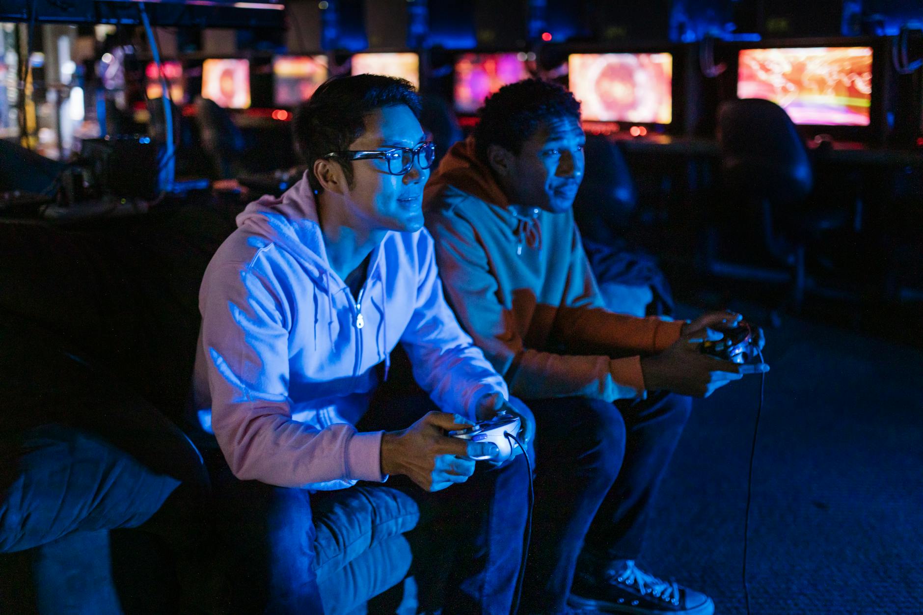 two men playing video game and one of them wearing blue ray glasses while gaming showcasing its benefits.
